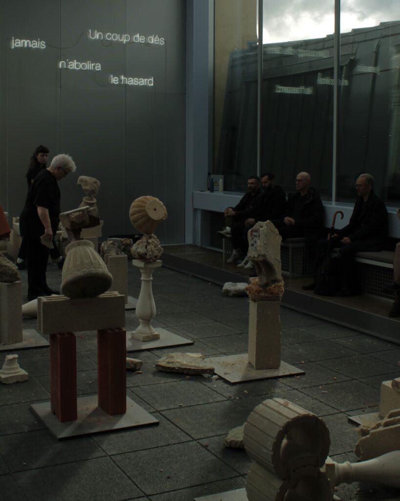 Rock balancing performance art creating environmental sculpture in Paris gallery