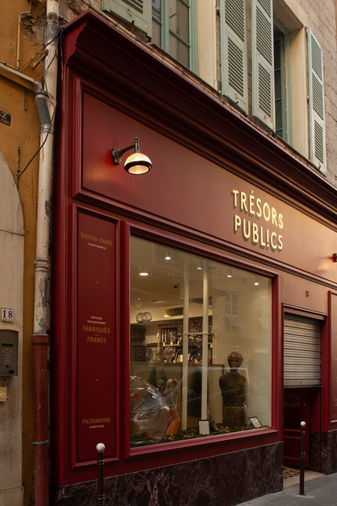 Window display featuring traditional French objects and heritage products at artisan boutique in Old Nice