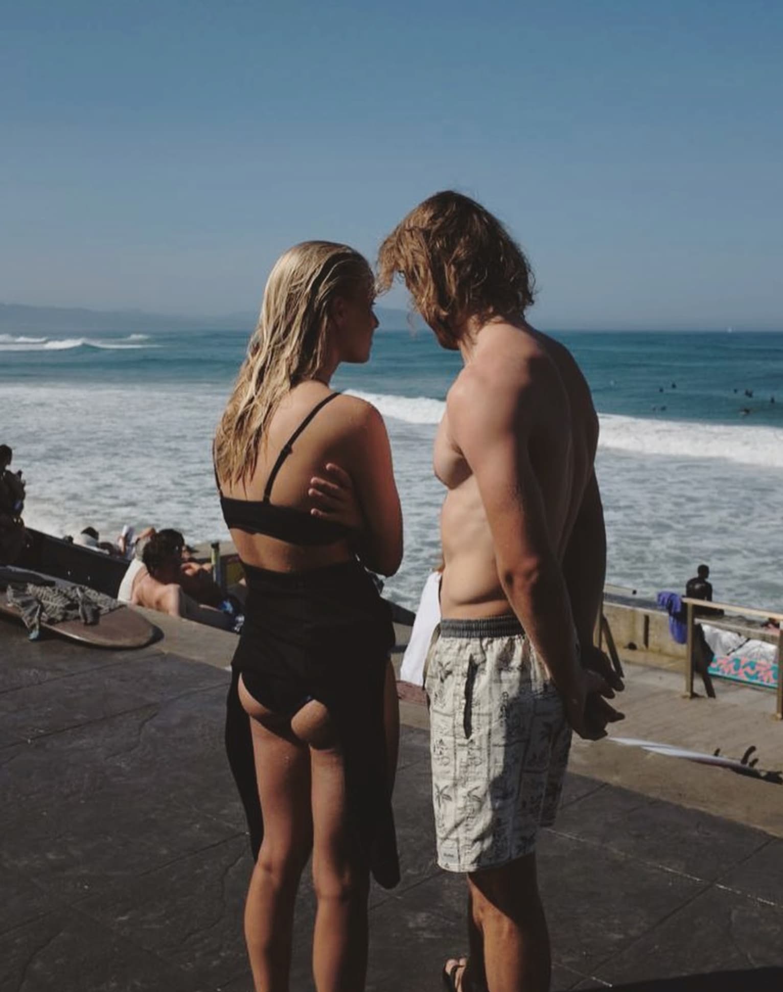 Yvan Canal Street 55 — two people standing by the sea, candid moment on the beach